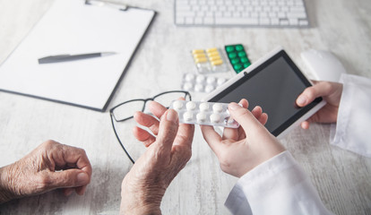 Doctor giving pills to elderly woman. Health, Medicine, Care