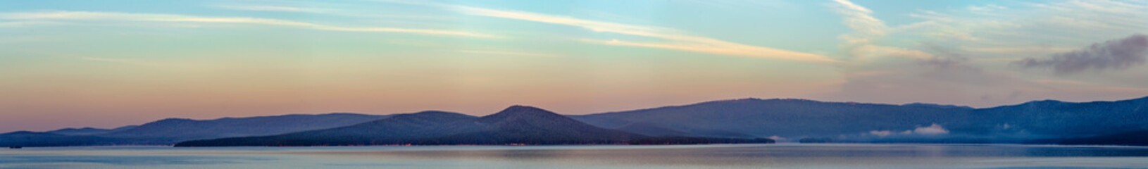Fototapeta na wymiar Foggy sunrise on a mountain lake