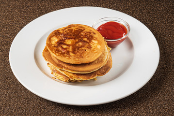 pancakes with strawberry sauce on the white plate