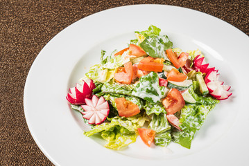 salad with fresh vegetables on the white plate