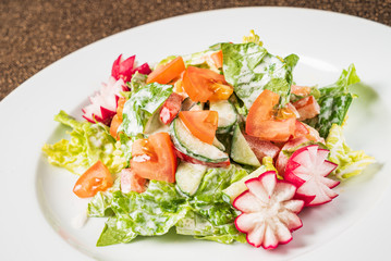 salad with fresh vegetables on the white plate