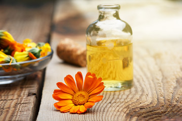 Marigold flowers of different colors are scattered on an old wooden table.