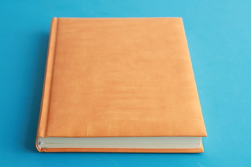 Fototapeta premium book with orange cover on colorful background