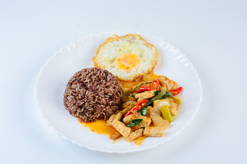Stir fry chicken sweet onion and peppers, served with brown rice and fried egg on white plate
