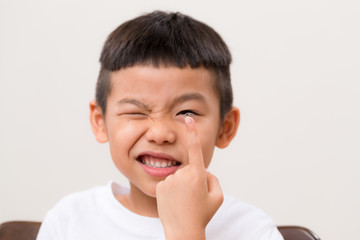 Kid hold with a contact lens with a smile