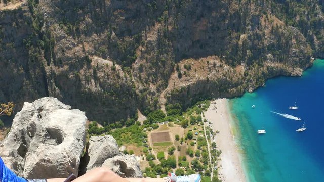 Young woman enjoying freedom and taking sun bath with beatiful viewn of Butterfly Valley on background in Turkey