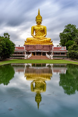 Fototapeta na wymiar Beautiful Big Golden Buddha statue against blue sky in Thailand temple,khueang nai District, Ubon Ratchathani province, Thailand.Amazing Buddha image with sunny sky clouds