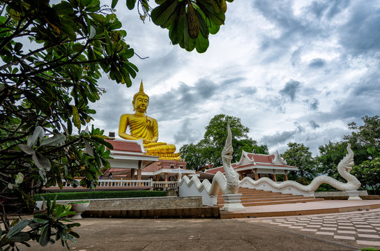 Beautiful Big Golden Buddha statue against blue sky in Thailand temple,khueang nai District, Ubon Ratchathani province, Thailand.Amazing Buddha image with sunny sky clouds