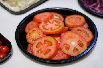 Sliced red  ​​tomatoes in a plate. Prepare vegetable salad.