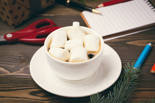 Cup of hot chocolate with marshmellow on wooden background