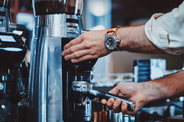 Fototapeta na wymiar Process of coffee making using brand new coffee machine at cafe by expirienced barista.
