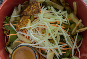 Spicy mango salad with sauce. Delicious vegetarian  vegan asian salad in red plate