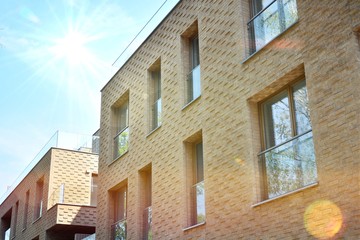 Modern apartment buildings on a sunny day with a blue sky. Facade of a modern apartment building.Glass surface with sunlight.