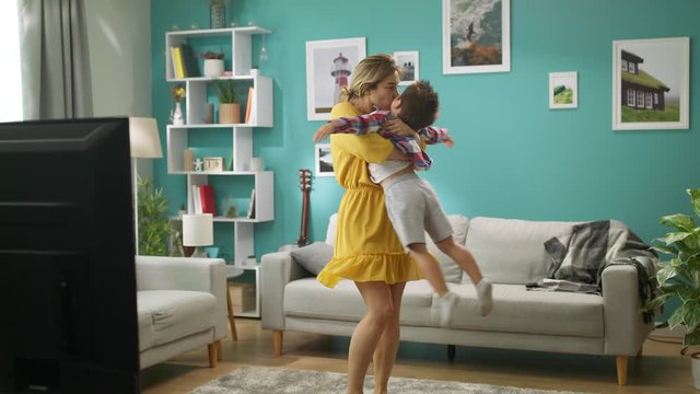 Mom and son are having fun whirling in their living room on the weekend.