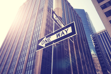 One way street signs against the sun in New York City, color toning applied, USA.
