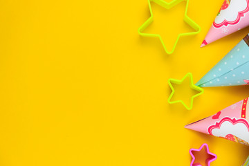 Birthday party caps, balloon and stars on yellow background. Colorful celebration background with various party.