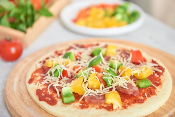 Raw pizza dough with tomato sauce, ingredients
