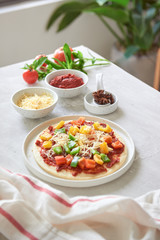 Raw dough for pizza preparation with ingredient: tomato sauce, mozzarella, ...