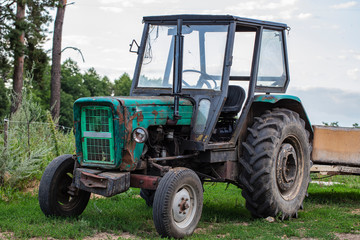 old green tractor standing outside 