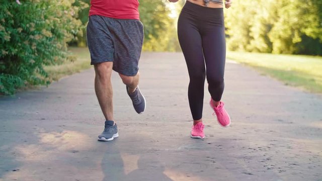 Low section of couple jogging in the park