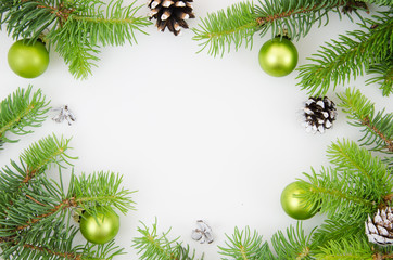 Christmas frame mockup. Pine cones, fir branches and green Christmas balls on white background. Flat lay