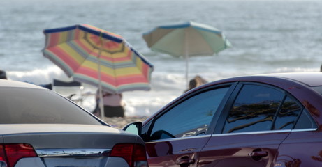 Beach umbrellas behind parking lot at Newport Beach park