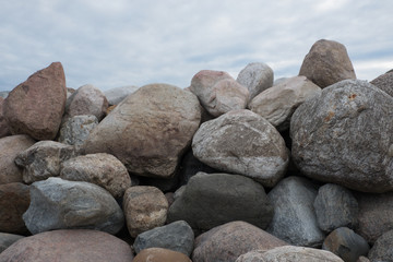 Retaining wall made of stones, boulders. Stone of volcanic rocks, granite, basalt, gabro. Bank protection on the sea beach. Protection of the coast from destruction by waves. Waterworks.