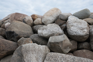 Retaining wall made of stones, boulders. Stone of volcanic rocks, granite, basalt, gabro. Bank protection on the sea beach. Protection of the coast from destruction by waves. Waterworks.