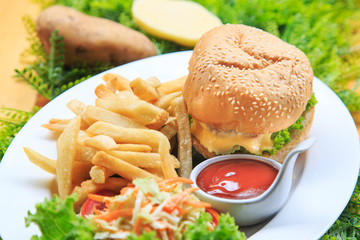 Beef burger serve with  french fried and salad/ Delicious burger with beef, tomato and cheese and lettuce/ Cheese burger Australian tenderlion/