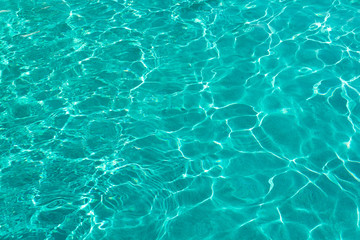Fototapeta na wymiar Water ripples on blue tiled swimming pool background. View from above
