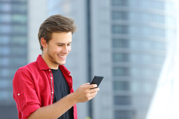 Happy entrepreneur using smart phone in the street