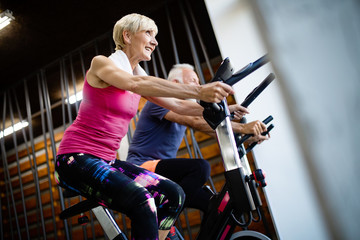 Fototapeta na wymiar Happy senior people doing indoor biking in a fitness club
