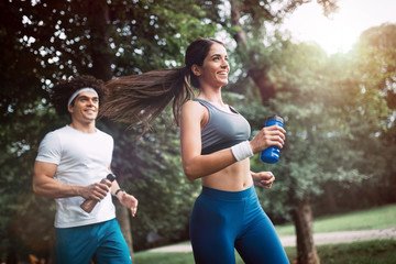 Happy young people jogging and exercising in nature