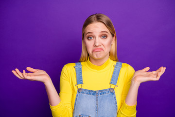 Portrait of indifferent person shrugging her shoulders wearing yellow turtleneck denim jeans...