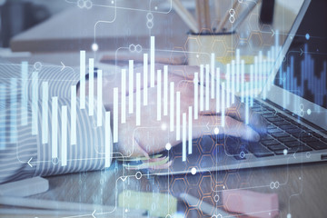 Multi exposure of stock market graph with man working on laptop on background. Concept of financial analysis.