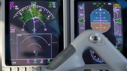 Closeup view of the navigation and guidance equipment in an Embraer 135 aircraft's cockpit behind the yoke
