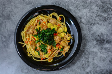 Hot and spicy chicken spaghetti, topping with crispy sweet basil and sliced baby corn