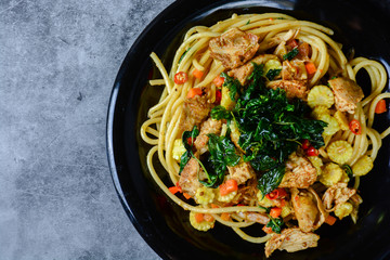 Hot and spicy chicken spaghetti, topping with crispy sweet basil and sliced baby corn