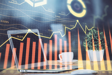 Stock market graph on background with desk and personal computer. Double exposure. Concept of financial analysis.