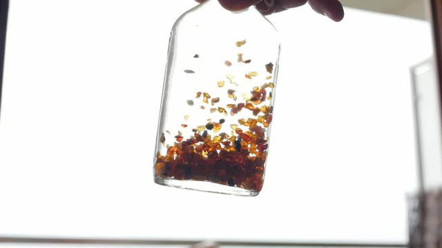 tincture of amber, pieces of amber in a bottle, slow motion