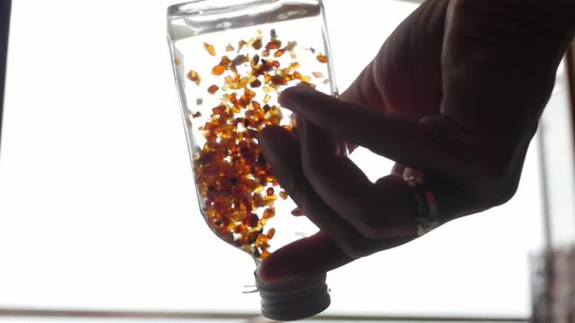 tincture of amber, pieces of amber in a bottle, slow motion