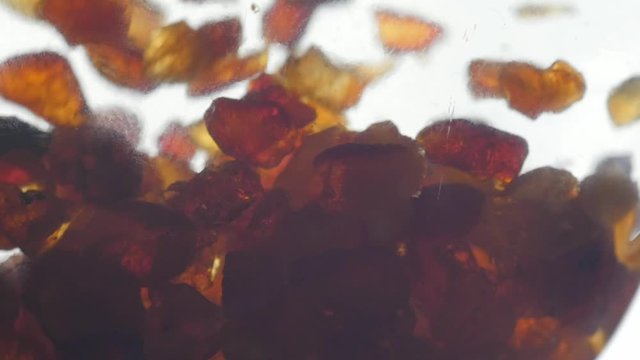 pieces of amber in water falling to the bottom slow motion