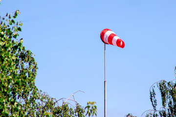 Windsock indicating wind on blue sky background.
