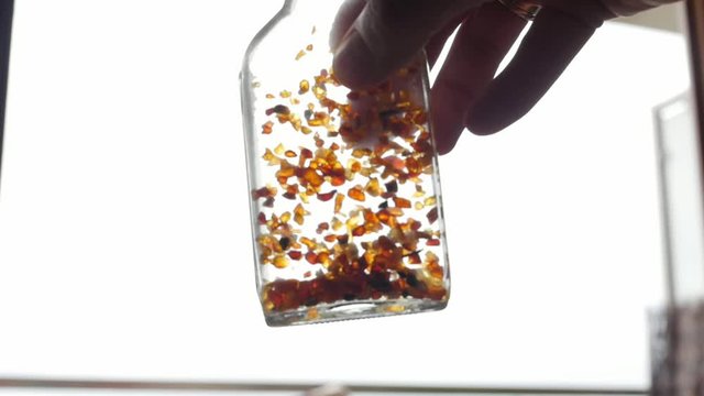 tincture of amber, pieces of amber in a bottle, slow motion