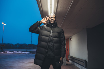 young black man standing outdoor gesture with hand looking the camera