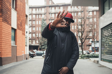portrait of young african man standing in the street ok gesture