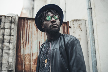 portrait of young african man standing in the street and looking further
