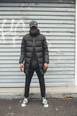 young african man standing in the street and looking down