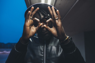 portrait of young black man standing outdoor showing hands