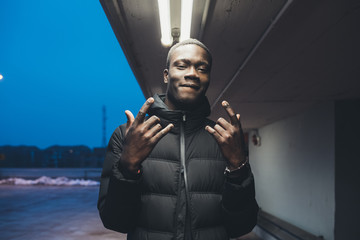portrait of young black man standing outdoor gesture with hand looking the camera